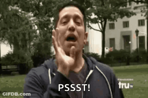 A Man Is Making A Funny Face In A Park With His Hand On His Face . GIF