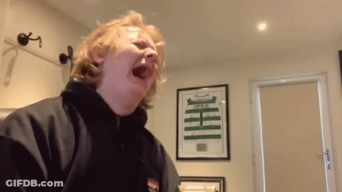 A Man Is Making A Funny Face In Front Of A Framed Picture That Says ' Empire ' GIF