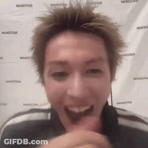 A Man Is Making A Funny Face In Front Of A Makestar Banner . GIF