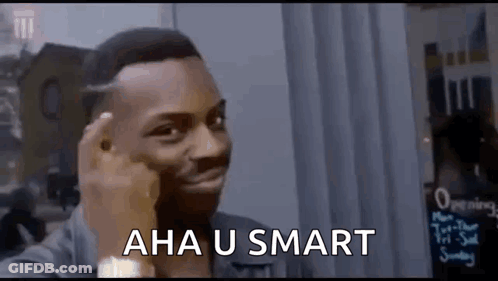 A Man Is Making A Funny Face While Holding His Finger To His Forehead And Says `` Aha U Smart '' . GIF
