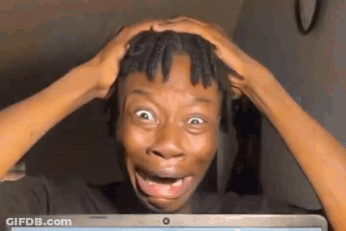 A Man Is Making A Funny Face While Looking At A Laptop Computer . GIF