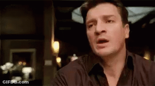 A Man Is Making A Funny Face While Sitting At A Table . GIF