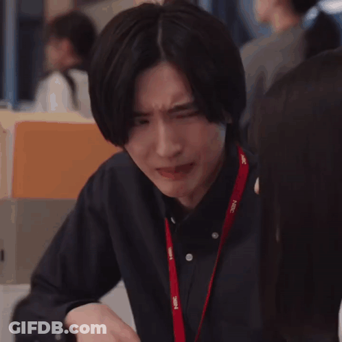 A Man Is Making A Funny Face While Sitting At A Table With His Hands Together . GIF