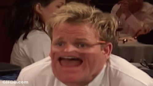 A Man Is Making A Funny Face While Sitting At A Table With His Mouth Open . GIF