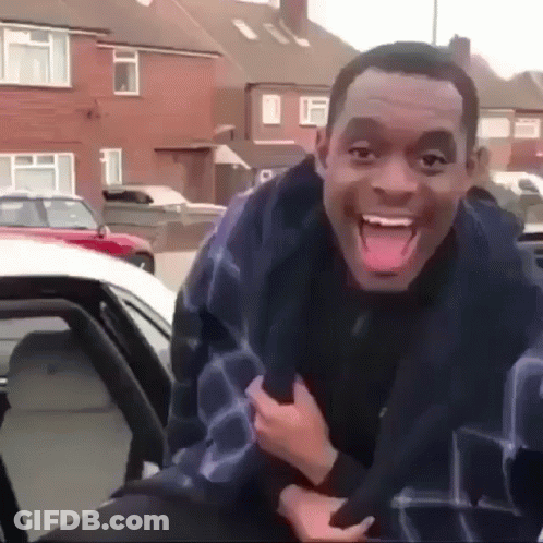 A Man Is Making A Funny Face While Sitting In A Car . GIF