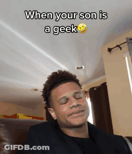A Man Is Making A Funny Face While Sitting On A Couch With The Caption When Your Son Is A Geek GIF