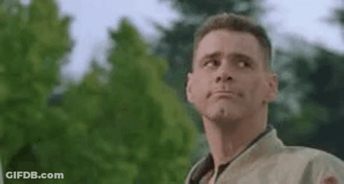 A Man Is Making A Funny Face While Standing In Front Of A Tree . GIF