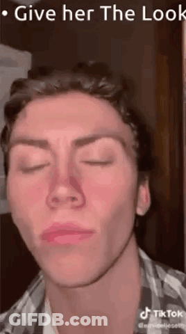A Man Is Making A Funny Face With His Eyes Closed And His Nose Is Red . GIF