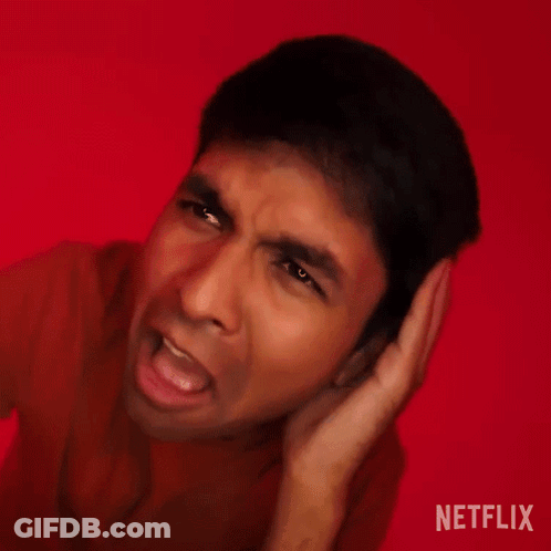 A Man Is Making A Funny Face With His Hands Behind His Ears . GIF