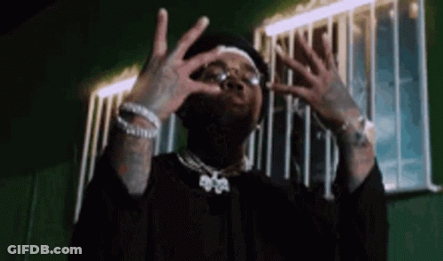A Man Is Making A Funny Face With His Hands In Front Of A Building . GIF
