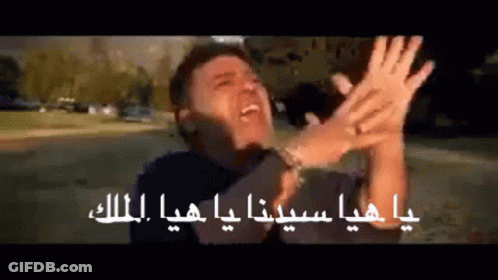 A Man Is Making A Funny Face With His Hands In The Air In Arabic GIF