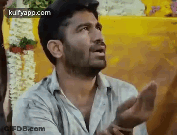 A Man Is Making A Funny Face With His Hands Outstretched . GIF