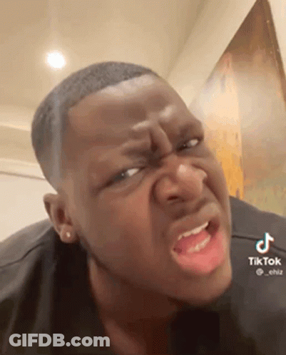 A Man Is Making A Funny Face With His Mouth Open And A Black Shirt On . GIF