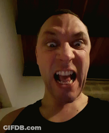 A Man Is Making A Funny Face With His Mouth Wide Open GIF