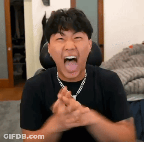 A Man Is Making A Funny Face With His Tongue Out While Wearing A Necklace . GIF