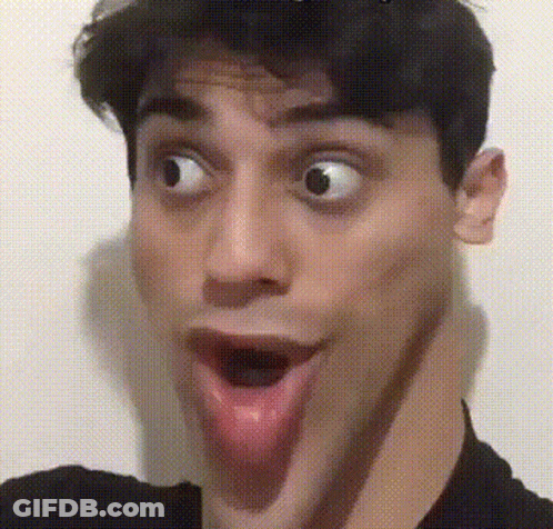 A Man Is Making A Funny Face With His Tongue Out GIF