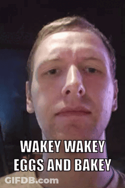 A Man Is Making A Funny Face With The Words Wakey Wakey Eggs And Bakey GIF