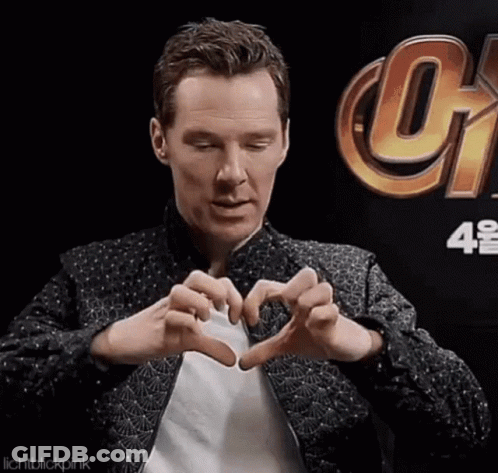A Man Is Making A Heart Shape With His Hands In Front Of A Sign That Says Infinity War . GIF