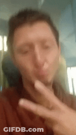 A Man Is Making A Peace Sign With His Hand GIF