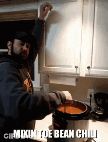 A Man Is Mixing Bean Chili In A Pot GIF