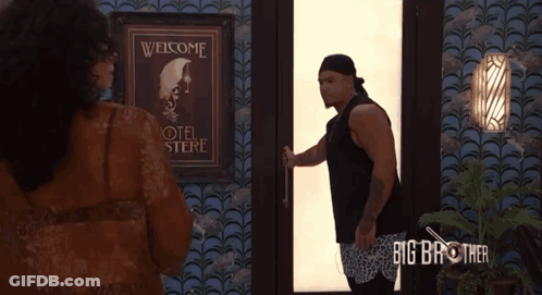 A Man Is Opening A Door In Front Of A Sign That Says " Welcome " GIF