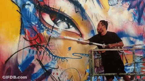 A Man Is Painting A Mural On A Wall With The Letter S On The Bottom GIF