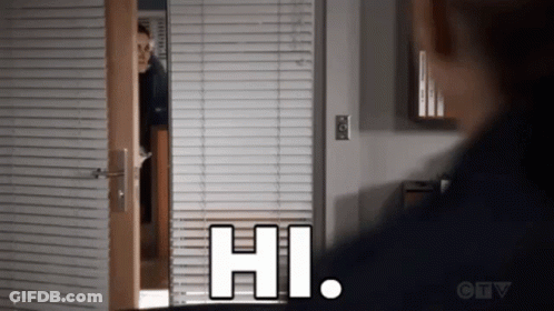A Man Is Peeking Out From Behind A Door With Blinds And Says Hi . GIF
