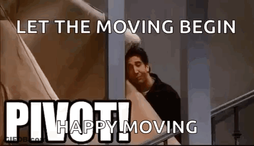 A Man Is Peeking Out From Behind A Wall With A Sign That Says `` Let The Moving Begin '' . GIF