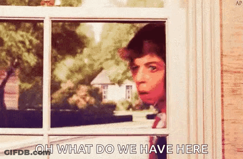 A Man Is Peeking Out Of A Window With The Words `` Oh What Do We Have Here '' Written On It . GIF