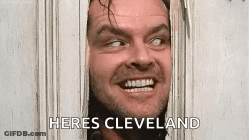 A Man Is Peeking Through A Hole In A Door And Smiling . GIF