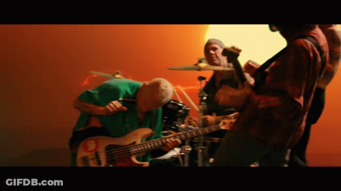A Man Is Playing A Bass Guitar With A Sticker On It GIF