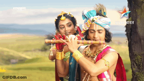 A Man Is Playing A Flute Next To A Woman With The Word Star India On The Bottom GIF