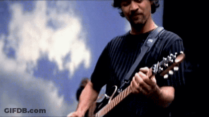 A Man Is Playing A Guitar In Front Of A Blue Sky GIF