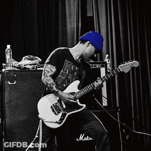 A Man Is Playing A Guitar In Front Of A Marshall Amp GIF