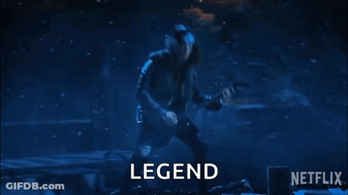 A Man Is Playing A Guitar On A Stage In Front Of A Crowd And The Word Legend Is On The Screen . GIF