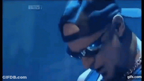 A Man Is Playing A Guitar On A Stage In Front Of A Drum Kit . GIF