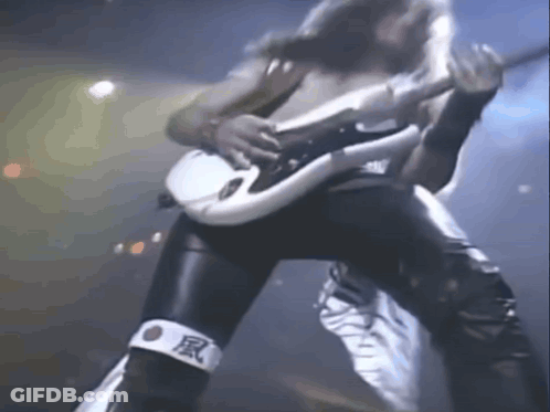 A Man Is Playing A Guitar On A Stage While Wearing A Bandage With Chinese Characters On It . GIF