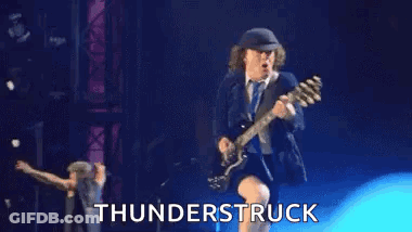 A Man Is Playing A Guitar On A Stage With The Words `` Thunderstruck '' Behind Him . GIF