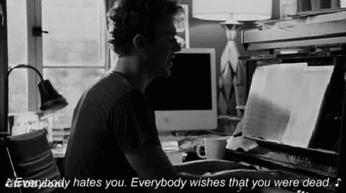 A Man Is Playing A Piano And Says Everybody Hates You Everybody Wishes That You Were Dead . GIF