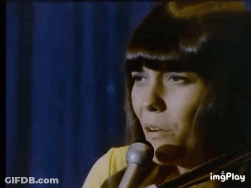A Man Is Playing A Piano In A Dark Room While Another Man Is Playing Drums In The Background . GIF