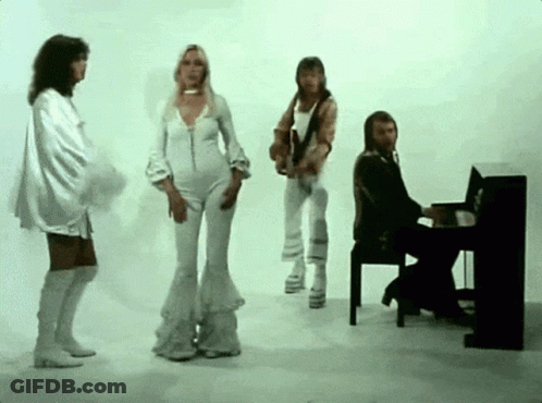 A Man Is Playing A Piano While A Group Of People Are Dancing GIF