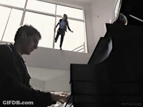 A Man Is Playing A Piano While A Woman Is Standing On A Window Sill GIF