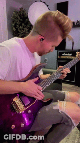 A Man Is Playing A Purple Guitar In Front Of A Marshall Amp GIF