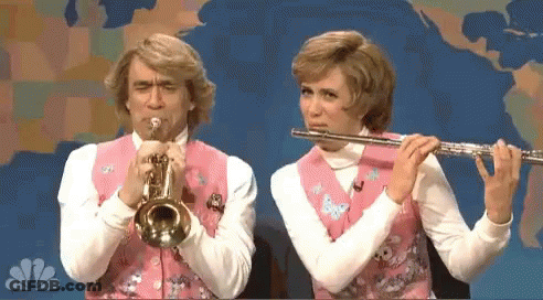 A Man Is Playing A Trumpet And A Woman Is Playing A Flute In Front Of A Map Of The World GIF