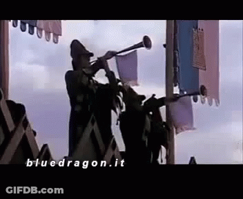 A Man Is Playing A Trumpet In Front Of A Crowd Of People In A Castle . GIF