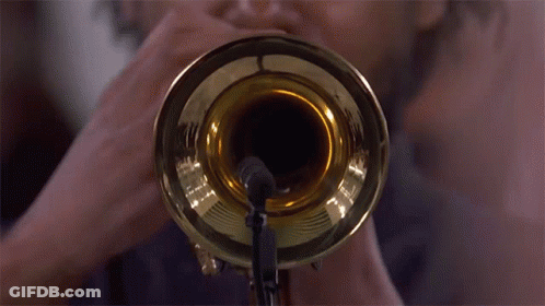 A Man Is Playing A Trumpet With A Microphone Attached To It GIF