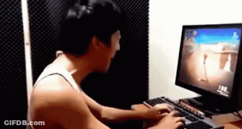 A Man Is Playing A Video Game On A Computer While Sitting At A Desk . GIF