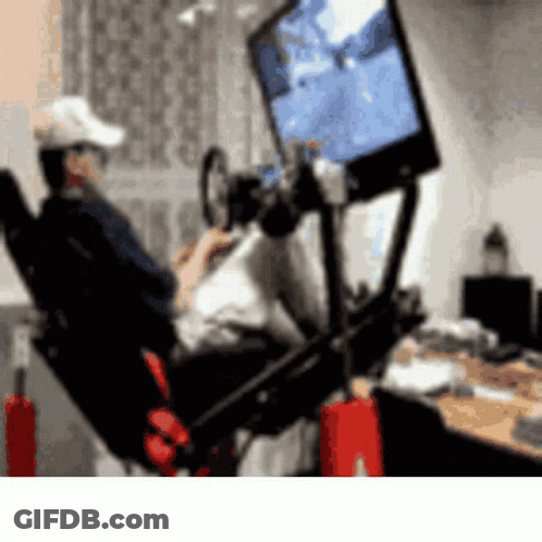 A Man Is Playing A Video Game On A Simulator GIF