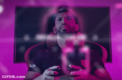 A Man Is Playing A Video Game While Wearing A Shirt That Says ' Ucd ' On It GIF