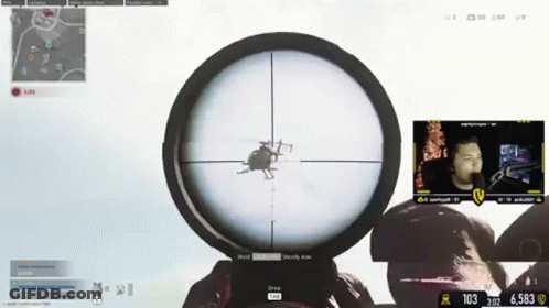 A Man Is Playing A Video Game With A Helicopter In The Scope Of His Sniper Rifle GIF